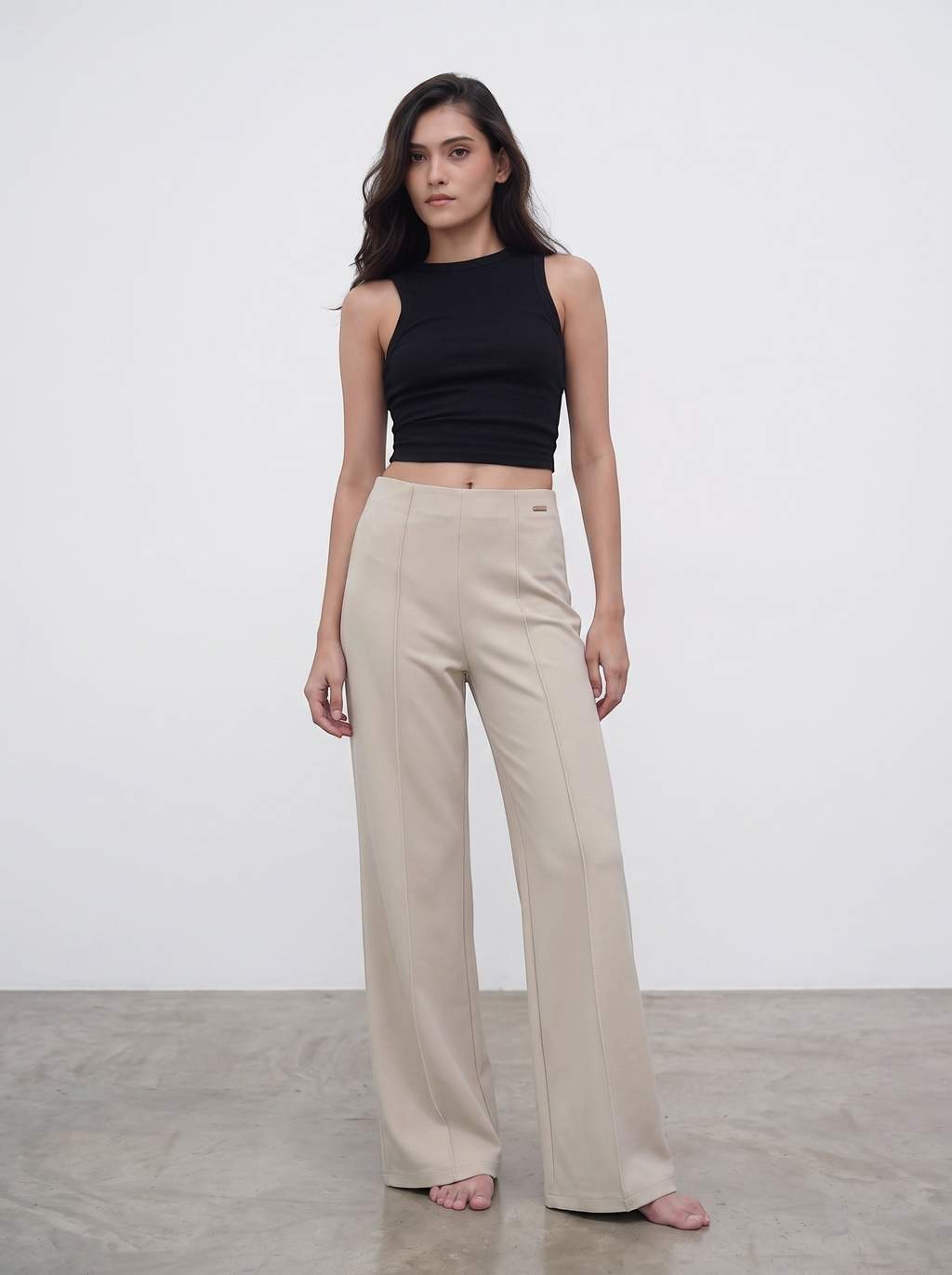 Model wearing duwies beige high-waisted wide-leg tailored trousers with front seam detail and a black sleeveless top.