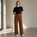 duwies high-waisted tobacco brown wide-leg tailored trousers worn by a woman with a black t-shirt and white sneakers
